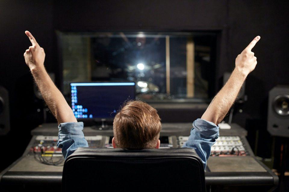 man at mixing console in music recording studio