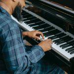 bearded black male musician playing piano