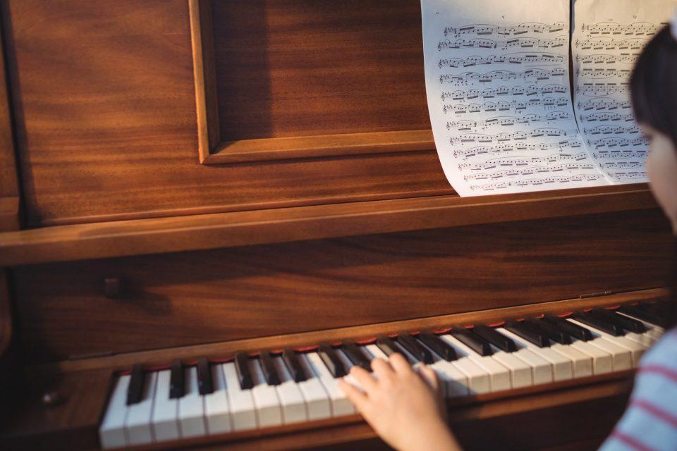Cropped image of girl practicing piano