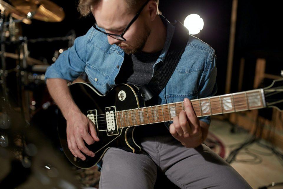 man playing guitar at studio rehearsal